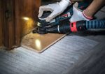 Bosch -Multifunktionswerkzeug mit Staubabsaugung zum Schneiden von Holzverkleidungen.